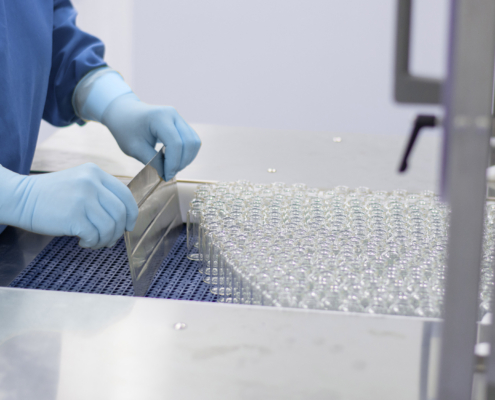The Process Of Loading Medical Ampoules For Vaccines Onto A Conveyor